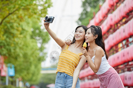 美女闺蜜旅行出游吃冰淇淋拍照图片