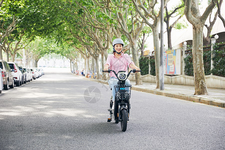 盔美女骑电动车低碳出行背景