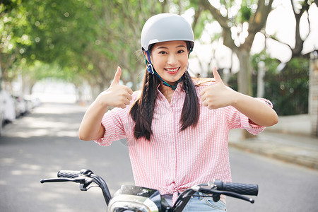 电动车标志美女户外骑电动车戴头盔背景