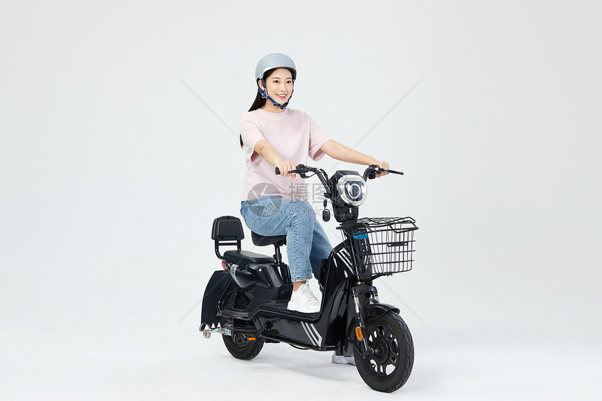 青年女性欢快骑电动车图片
