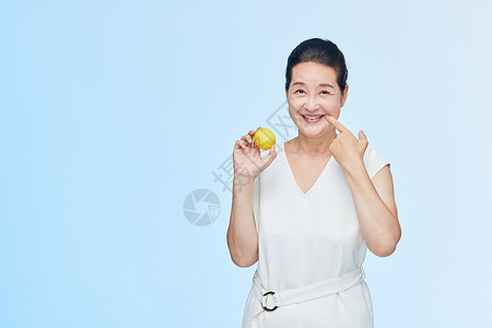 老年女性手拿柠檬展示高清图片