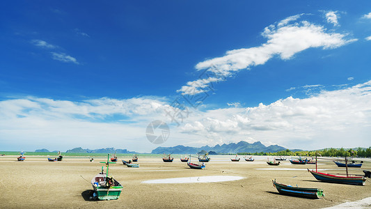 华欣海滩泰国华欣夏日海滨大海退潮后沙滩搁浅的渔船背景