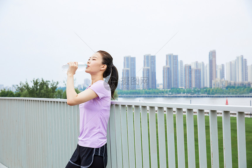 美女在户外公园里喝水休息图片