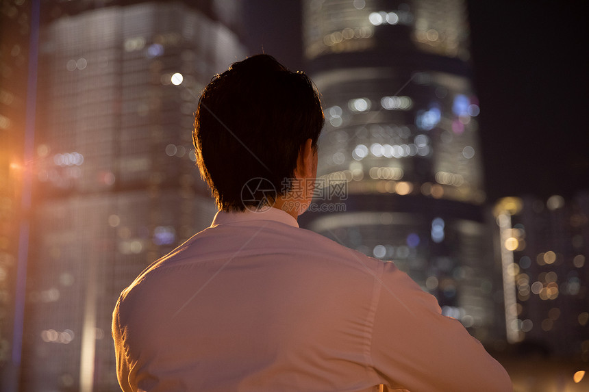 夜晚天桥上的都市商务男性背影图片