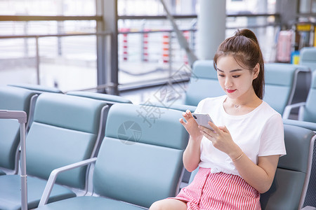 美女出游旅行在机场候机玩手机中国人高清图片素材