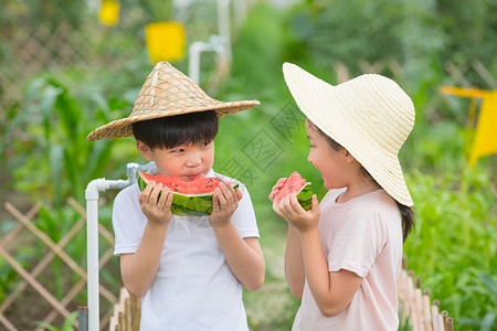 戴帽子的小男孩男孩和女孩在农场吃西瓜背景