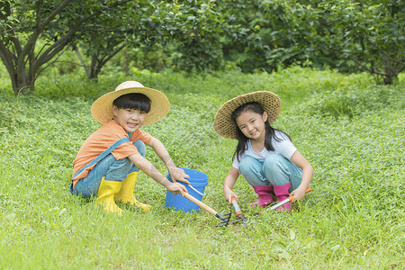 男孩女孩开心的在草地中种树图片