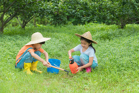 草地中的女孩男孩女孩开心的在草地中种树背景