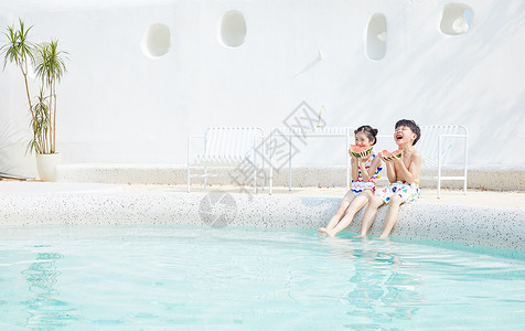 开心大笑的小男孩夏天小男孩和小女孩坐在泳池边开心吃西瓜背景