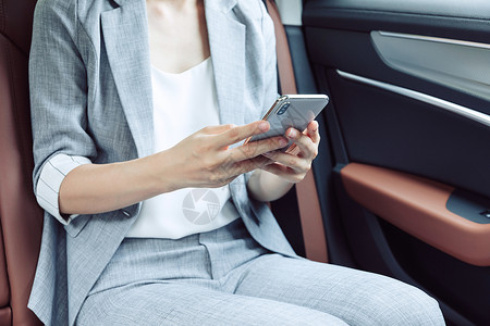 商务女性白天在汽车上看手机高清图片