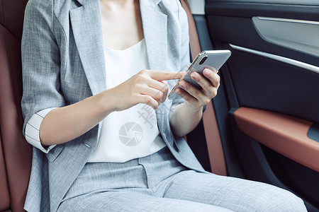 商务女性白天在汽车上看手机高清图片