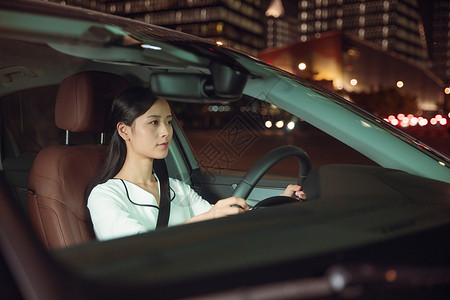 夜晚女性专车司机驾车试驾高清图片素材