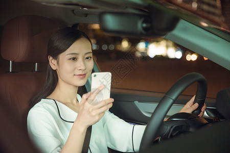 夜晚女性专车司机手机接单开车高清图片素材