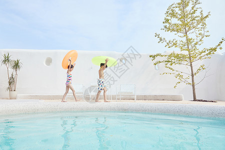 夏天游泳男孩男孩女孩拿着游泳圈在泳池边行走背景