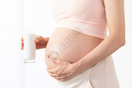 孕期营养孕妇手拿牛奶背景