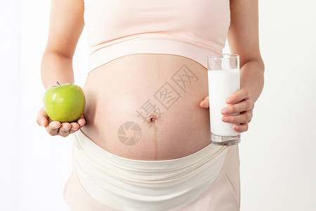 孕期营养孕妇手拿苹果和牛奶背景