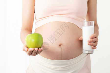 手拿苹果素材孕妇手拿苹果和牛奶背景