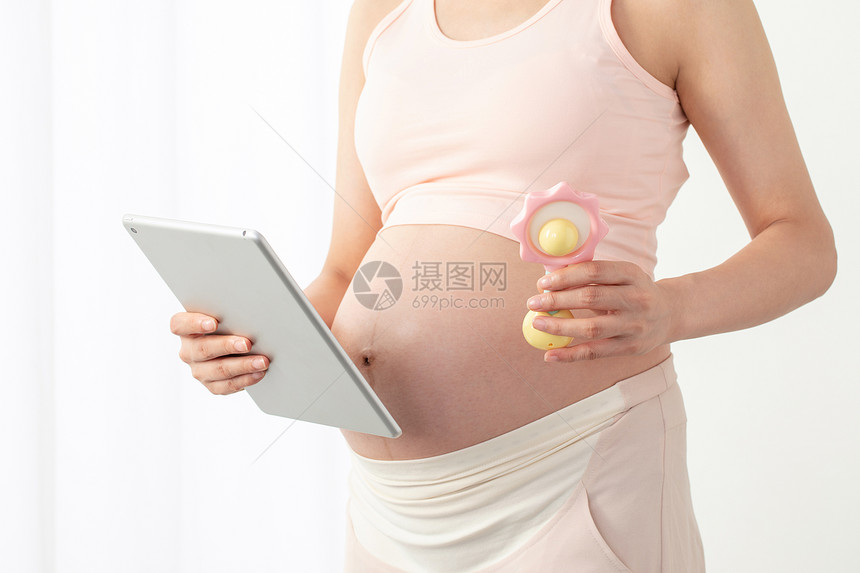 孕妇拿着平板电脑和玩具图片