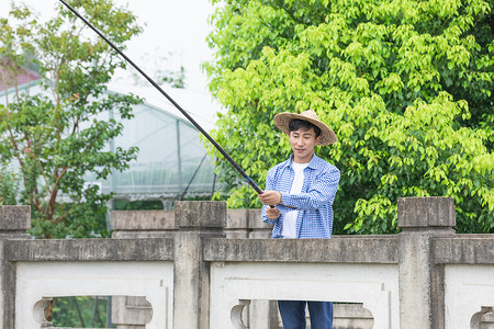 农夫乡间河岸钓鱼图片