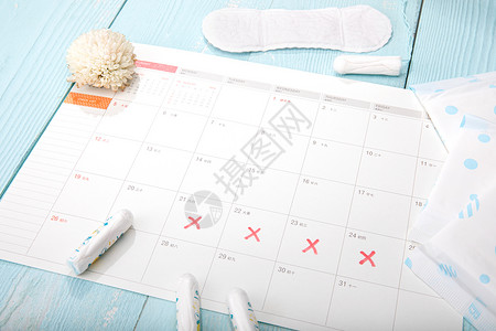 健康日历蓝色桌面上的女性卫生用品背景