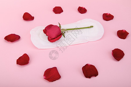 一次性卫生用品粉色背景上的卫生巾和鲜花背景