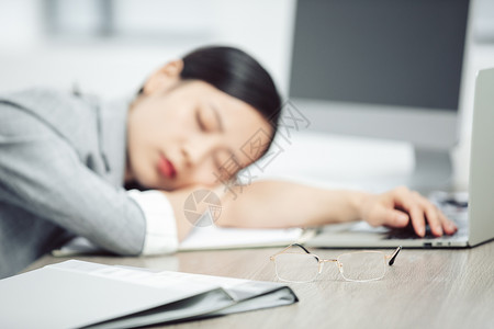 商务女性疲倦趴在桌子上睡觉背景