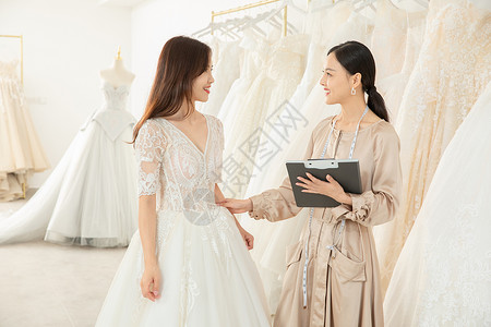 准新娘婚纱店与设计师沟通定制婚纱微笑高清图片素材