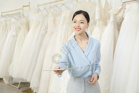 递平板电脑给顾客的婚纱店服务员图片