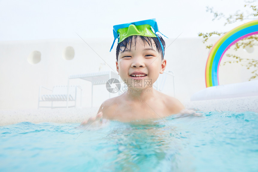 小男孩泳池里开心玩水图片