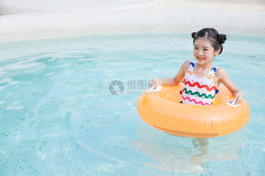 小女孩在泳池里面用游泳圈游泳图片