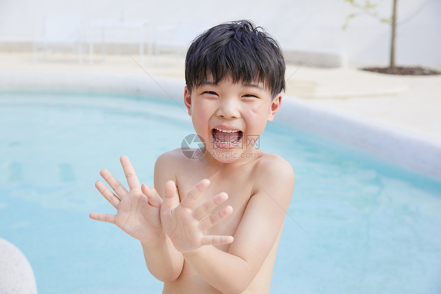 小男孩泳池里开心玩水图片