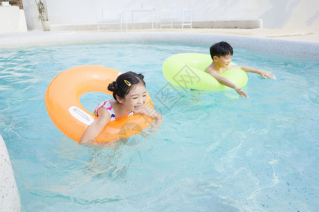 赢在暑假快乐学习快乐儿童使用游泳圈在泳池玩耍背景