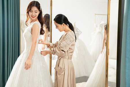 在镜子前试穿婚纱的准新娘背景图片