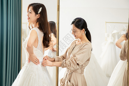 精致服务在镜子前试穿婚纱的准新娘背景