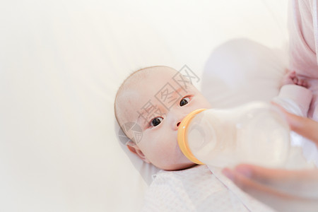 妈妈给宝宝用奶瓶喂奶背景图片