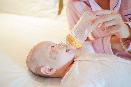 吃奶的婴儿妈妈给宝宝用奶瓶喂奶背景