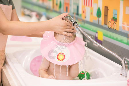 阿姨给婴幼儿洗澡洗头特写高清图片