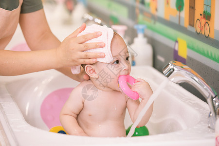 阿姨给婴幼儿洗澡擦干头发特写背景图片