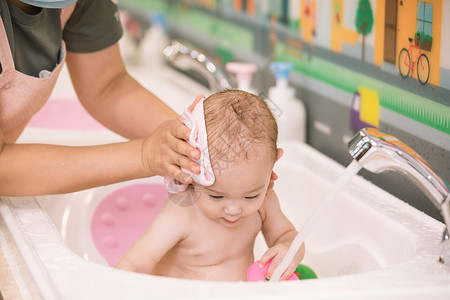 阿姨给婴幼儿洗澡擦干头发特写高清图片