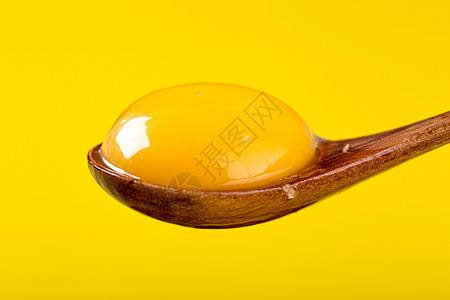 鸡叉勺吃木勺里的鸡蛋黄背景