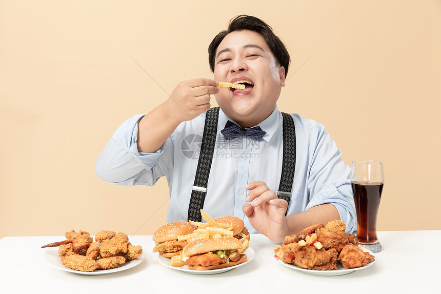 肥胖男士开心吃薯条图片