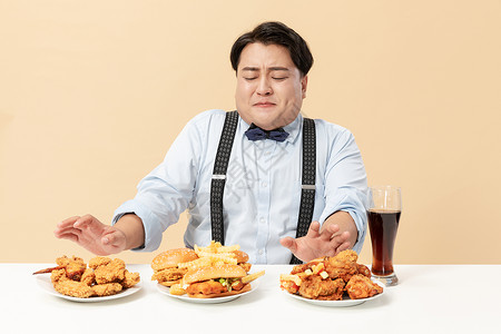 高热量食品汉堡旁男生拒绝高热量食物背景