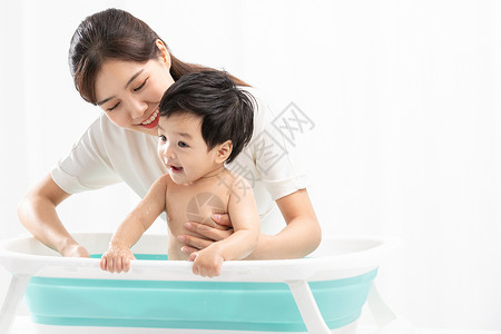 洗澡的孩子年轻妈妈给孩子洗澡背景