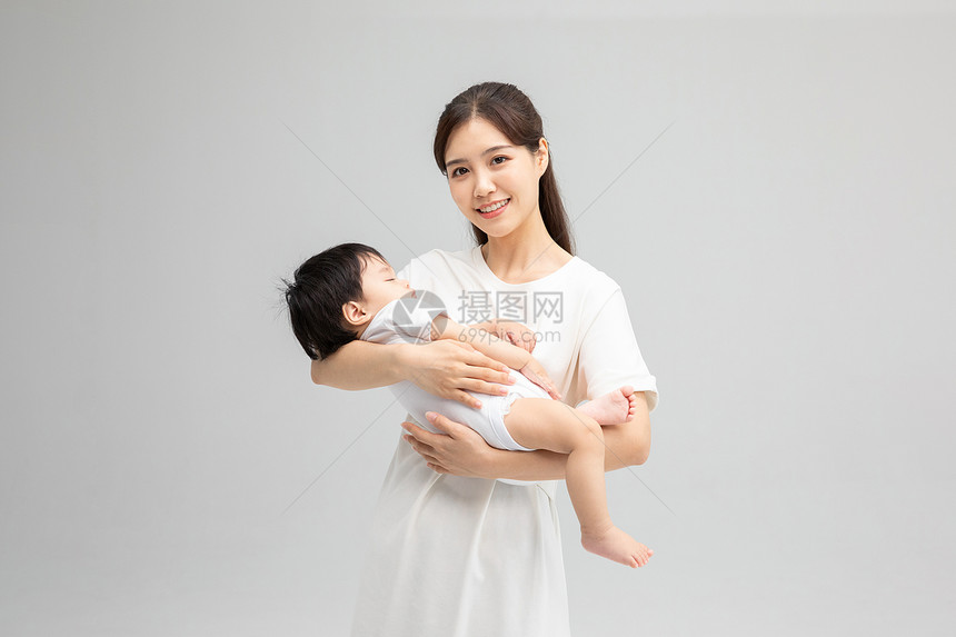 年轻妈妈抱着熟睡的孩子图片