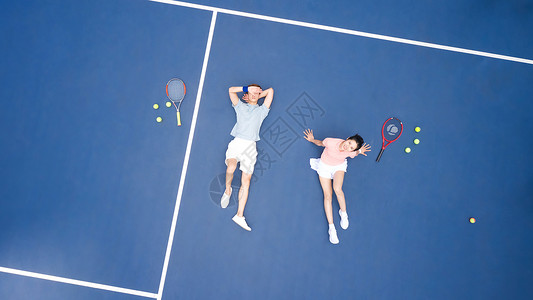 躺在网球场地上休息的青年情侣高清图片