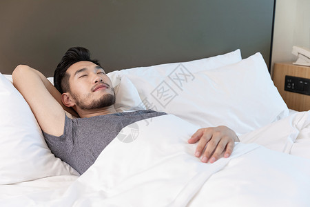青年男性在酒店里睡觉休息背景图片