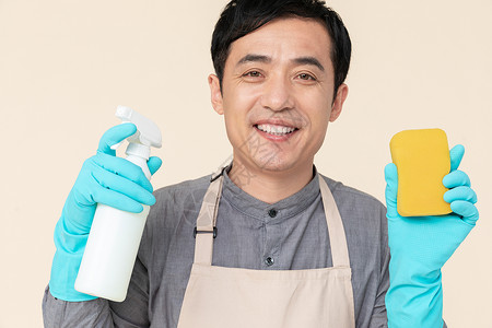 手持喷壶与海绵做清洁的家政服务男性清洁剂高清图片素材