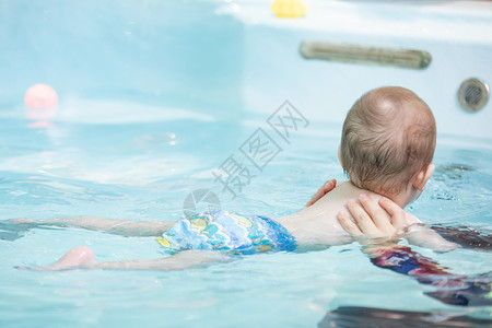 亲子游泳比赛母亲带着婴儿水池游泳特写背景