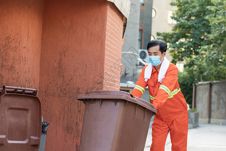 推垃圾桶到垃圾站的环卫工人防护高清图片素材