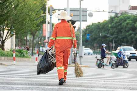 随手丢垃圾拎着垃圾袋与扫帚的环卫工人过马路背景